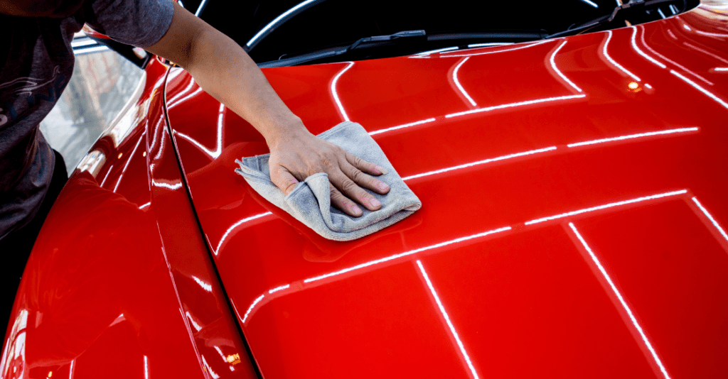 Wiping down a car with red Feynlab coating